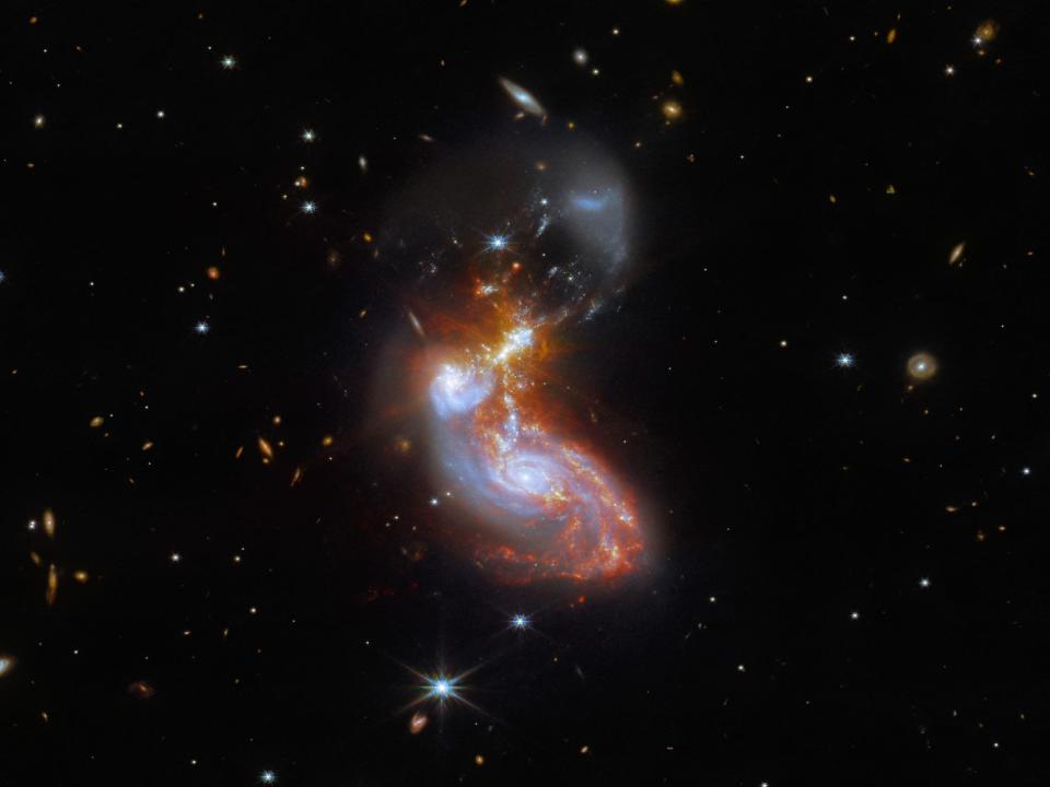 two colorful galaxies merging in space