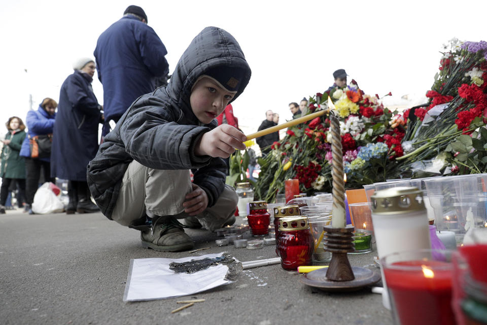 Boy lighting candle at memorial