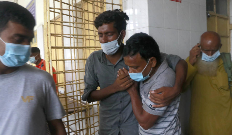 A patient, center, is assisted at the Medical College Hospital in Rajshahi, 254 kilometers (158 miles) north of the capital, Dhaka, Bangladesh, June 16 2021. Rajshahi has become one of the latest hotspots for the deadlier delta variant of the coronavirus. Bangladeshi authorities are increasingly becoming worried over the quick spread of coronavirus in about two dozen border districts close to India amid concern that the virus could devastate the crowded nation in coming weeks. (AP Photo/ Kabir Tuhin)