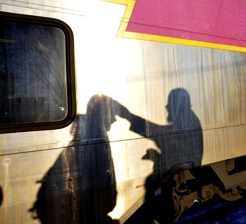 Father Chris Peschel of St. John's parish offers ashes to a commuter at the downtown Attleboro commuter station on Ash Wednesday, March 6, 2019, in Attleboro, Mass. (Mark Stockwell/The Sun Chronicle via AP)