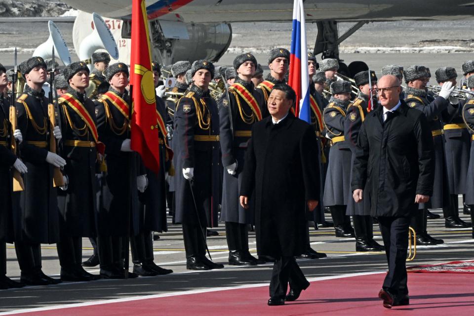 China's President Xi Jinping, accompanied by Russian Deputy Prime Minister Dmitry Chernyshenko, walks past guards during a welcoming ceremony at Moscow's Vnukovo airport on Monday.