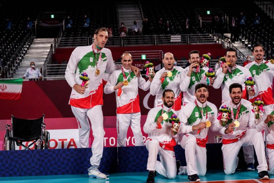 Morteza Mahrzadselakjani poses with team mates during the Iranian victory ceremony after the final match of sitting volleyball.