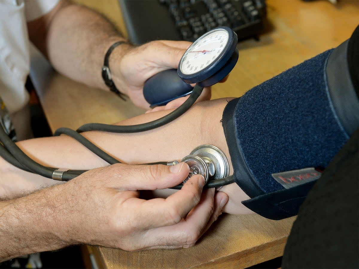 A GP checking a patient's blood pressure (PA)