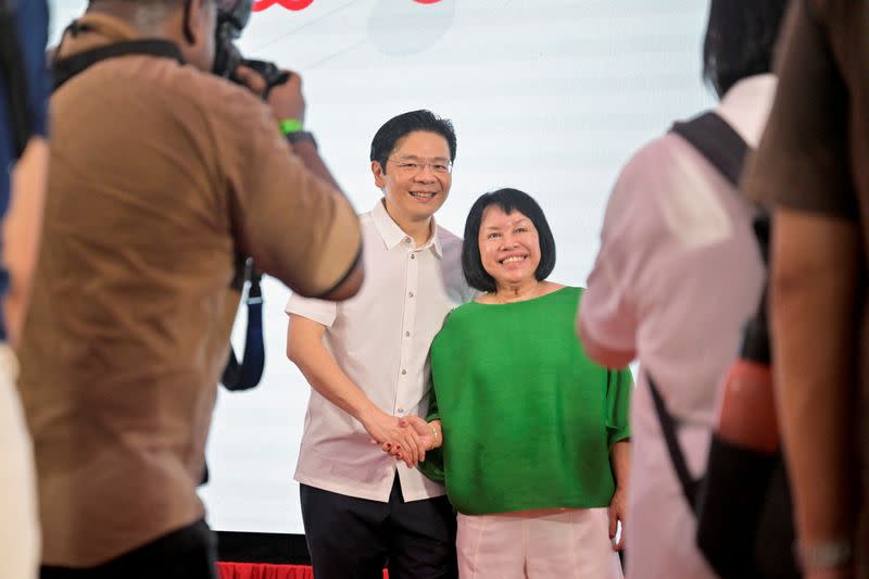 Singapore's fourth Prime Minister, Lawrence Wong, takes photos with a supporter at a community event after the swearing-in ceremony in Singapore