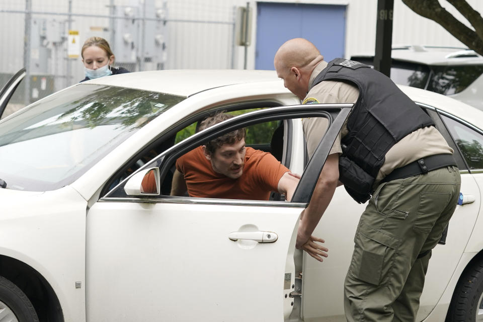 Kevin Burton-Crow, right, of the Thurston Co. Sheriff's Dept., takes Logan Vieira, center, an actor playing a person involved in a domestic violence situation, out of a vehicle during a training class at the Washington state Criminal Justice Training Commission, Wednesday, July 14, 2021, in Burien, Wash. Washington state is embarking on a massive experiment in police reform and accountability following the racial justice protests that erupted after George Floyd's murder last year, with nearly a dozen new laws that took effect Sunday, July 25, but law enforcement officials remain uncertain about what they require in how officers might respond — or not respond — to certain situations, including active crime scenes and mental health crises. (AP Photo/Ted S. Warren)