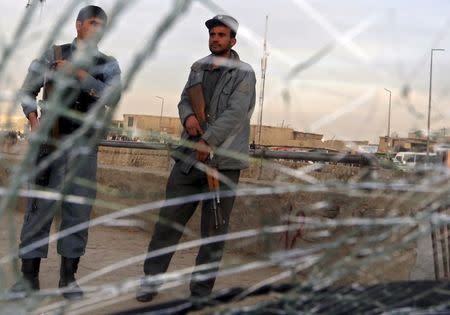 Afghan policemen are seen through a cracked window of a vehicle at the site of a suicide attack in Kabul March 25, 2015. REUTERS/Mohammad Ismail