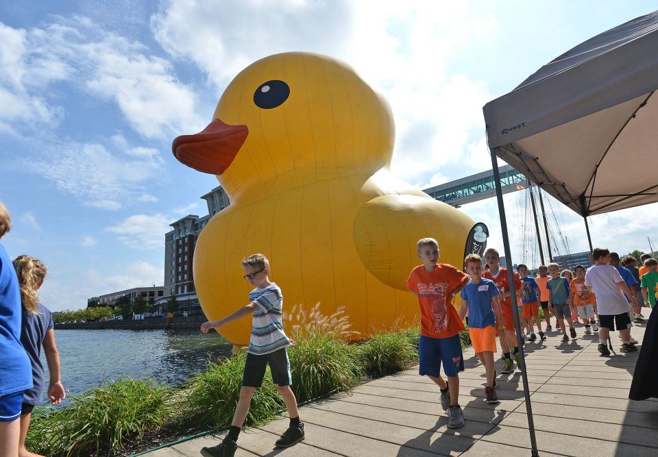 Schoolchildren walk past the World's Largest Rubber Duck near the west basin of Dobbins Landing on Presque Isle Bay during Tall Ships Erie 2016. It will return this week for Tall Ships Erie along with a one-story "baby" duck. CHRISTOPHER MILLETTE FILE PHOTO/ERIE TIMES-NEWS]