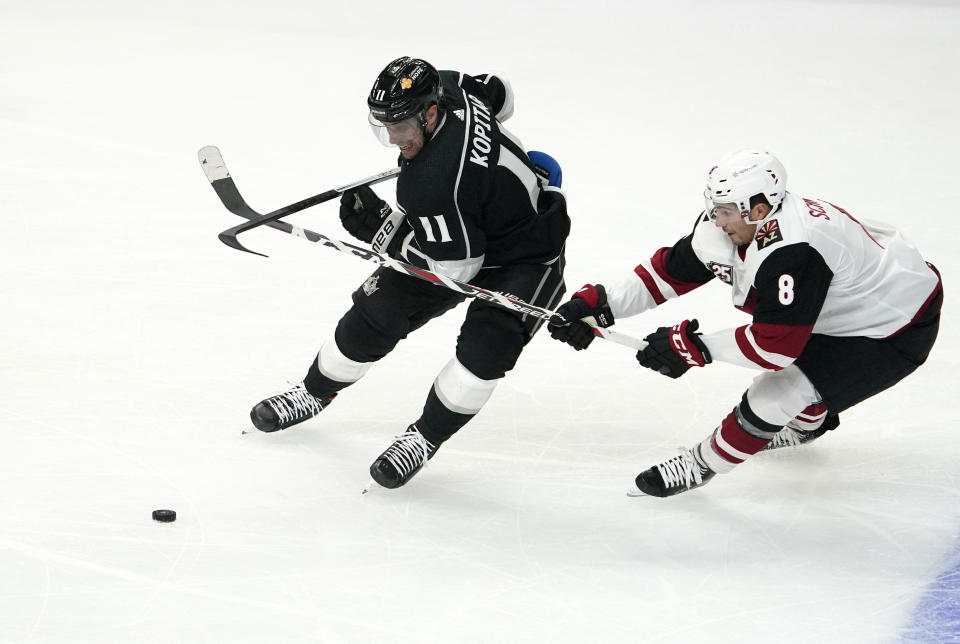 Los Angeles Kings center Anze Kopitar, left, and Arizona Coyotes center Nick Schmaltz battle for the puck during the first period of an NHL hockey game Wednesday, March 3, 2021, in Los Angeles. (AP Photo/Mark J. Terrill)