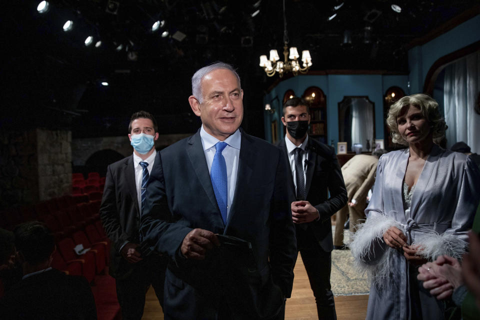 Israeli Prime Minister Benjamin Netanyahu meets Israeli actress Carmit Mesilati Kaplan, right, during a visit to the Khan theater ahead of the re-opening of the culture sector, in Jerusalem on Tuesday, Feb. 23, 2021. (Ohad Zwigenberg/Pool Photo via AP)