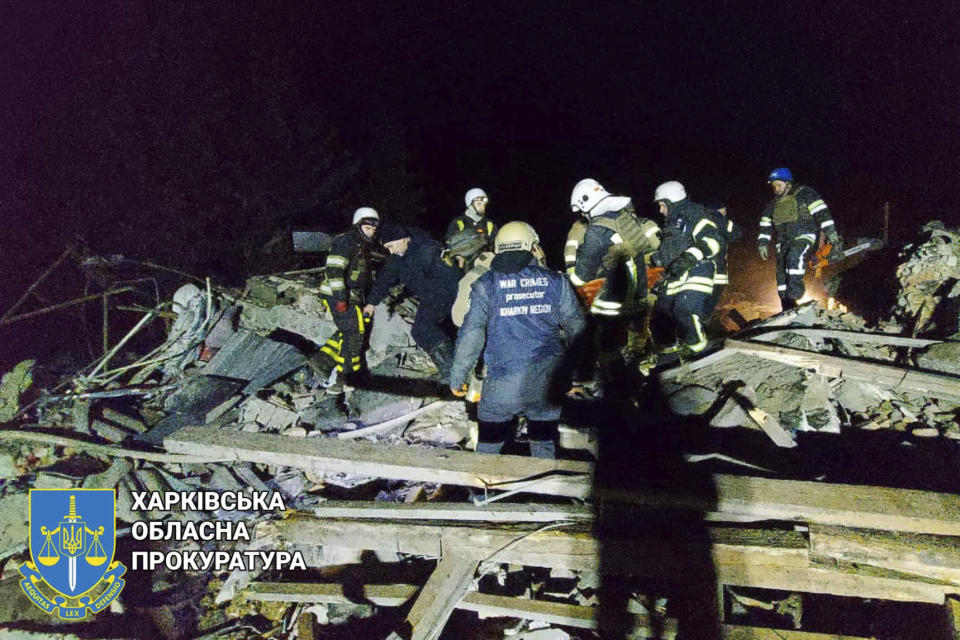 In this photo provided by Kharkiv Regional Prosecutor's Office, firefighters examine the site of Russia's missile attack that hit an apartment building in Kharkiv Region, Ukraine, Thursday, Feb. 15, 2024. (Kharkiv Regional Prosecutor's Office/ via AP)