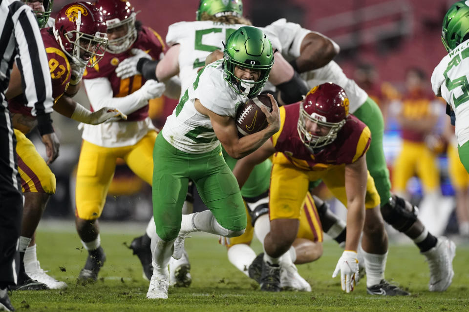 Oregon running back Travis Dye (26) runs the ball during the first quarter of an NCAA college football game for the Pac-12 Conference championship against Southern California Friday, Dec 18, 2020, in Los Angeles. (AP Photo/Ashley Landis)