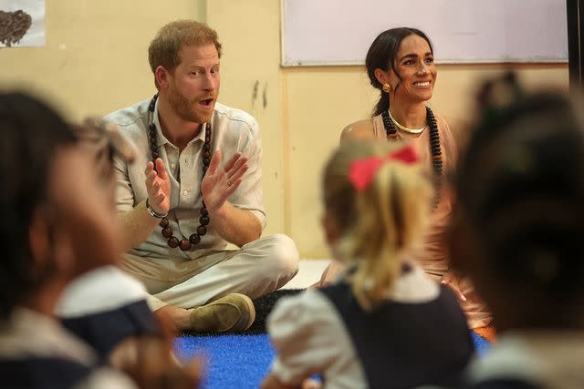 <p>KOLA SULAIMON/AFP via Getty</p> Britain's Prince Harry (L), Duke of Sussex, and Britain's Meghan (R), Duchess of Sussex, meet with children during their visit at the Lightway Academy in Abuja on May 10, 2024 as they visit Nigeria as part of celebrations of Invictus Games anniversary.