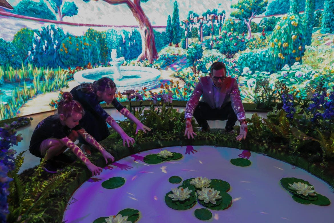 Stephen Nottingham, co-founder Frendesign, shows a pair of young visitors the interactive pond in the Landscape Gallery at the Telfair Children's Art Museum. The interactive gallery is designed to immerse you into the world of an Impressionist painter.