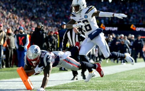 Sony Michel #26 of the New England Patriots scores a touchdown as he is defended by Casey Hayward #26 of the Los Angeles Chargers during the first quarter of the AFC Divisional Playoff Game at Gillette Stadium on January 13, 2019 in Foxborough, Massachusetts - Credit: Getty