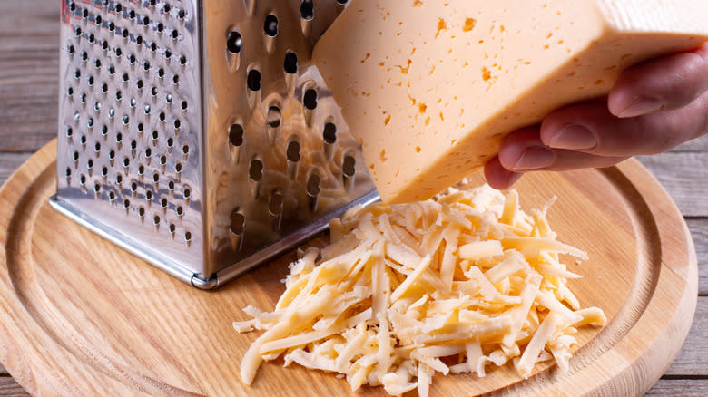 grating cheese on cutting board