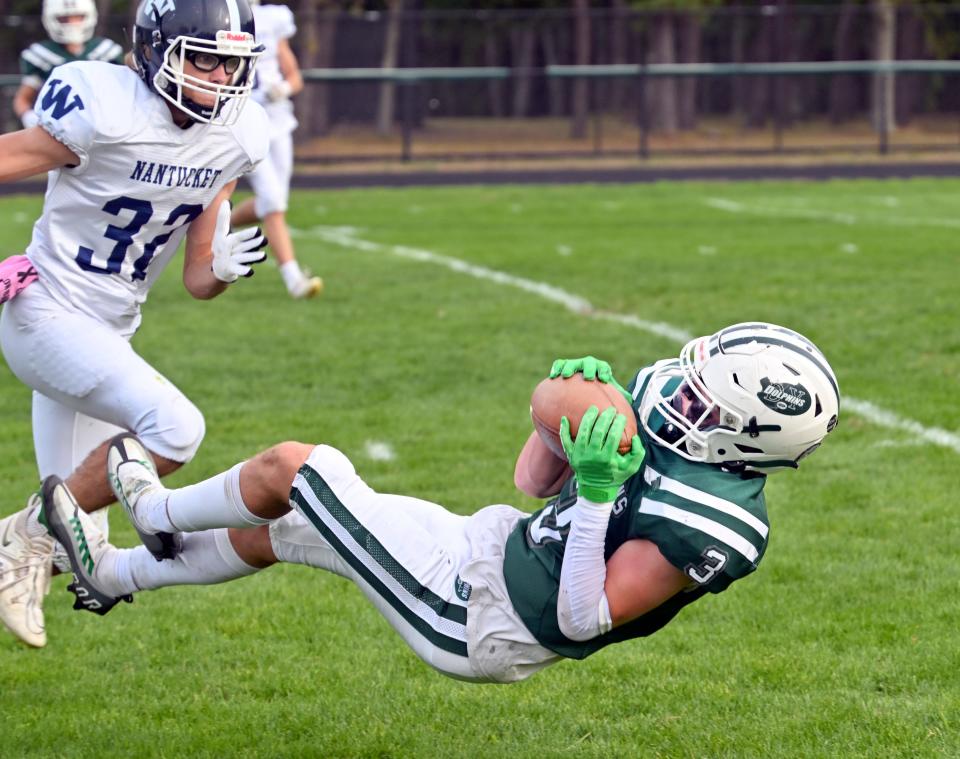 Jake Bohlin of Dennis-Yarmouth lays out to catch a pass as Griffin Fox of Nantucket closes in during a Sept. 30, 2022 game.