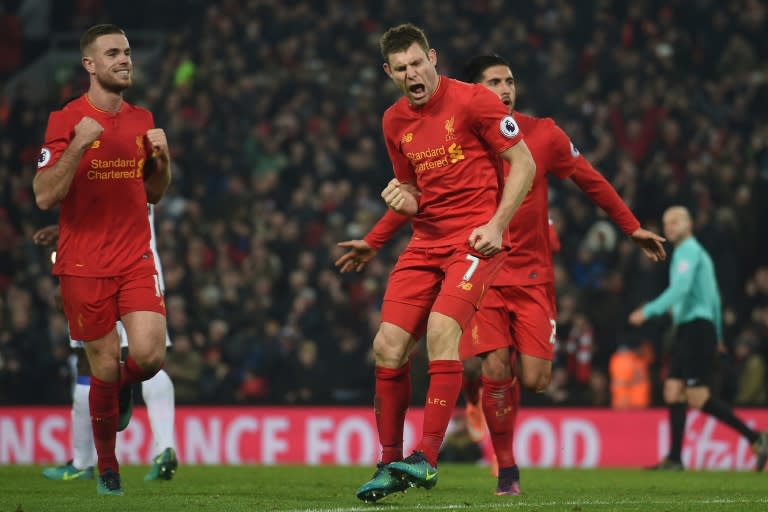 Liverpool's midfielder James Milner (C) celebrates after scoring their second goal from the penalty spot with midfielder Jordan Henderson (L) and midfielder Emre Can (R) during the Premier League football match against Sunderland November 26, 2016