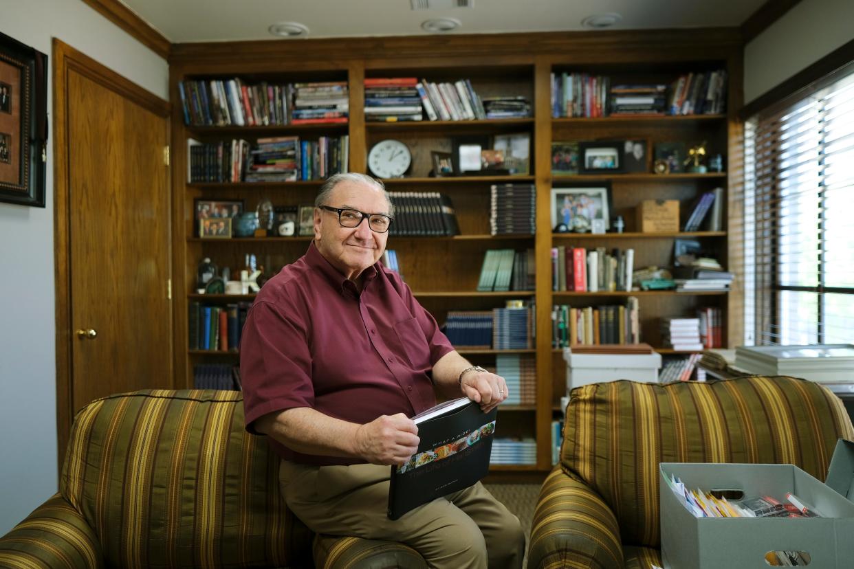 Bob Burke, historian, author and lawyer, holds one of his recent books, "What a Ride: The Life of Hal Smith," on April 11.