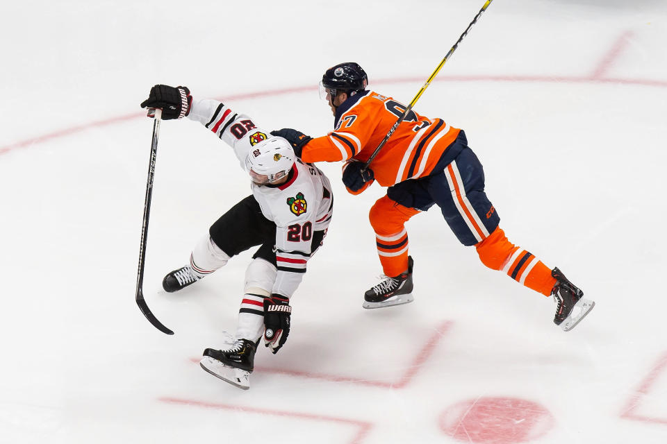 Edmonton Oilers' Connor McDavid (97) works against Chicago Blackhawks' Brandon Saad (20) during the second period of an NHL hockey playoff game Monday, Aug. 3, 2020, in Edmonton, Alberta. (Codie McLachlan/The Canadian Press via AP)