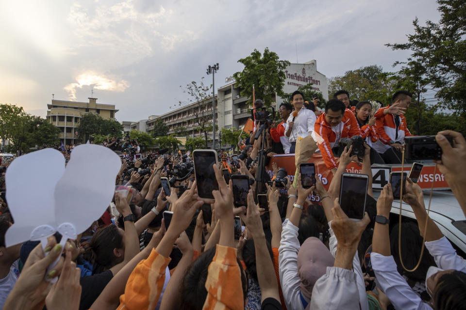 Pita Limjaroenrat, center, (white shirt) leader of Move Forward Party, waves to his supporters, in Bangkok Monday, May 15, 2023. Fresh off a stunning election victory in which they together captured a majority of seats in the House of Representatives, Thailand's top two opposition parties began planning Monday for the next stage in their bid to replace the military-dominated government. (AP Photo/Wason Wanichakorn)