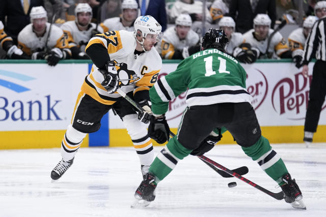 Pittsburgh Penguins center Sidney Crosby (87) makes a pass as Dallas Stars center Luke Glendening (11) defends in the second period of an NHL hockey game, Thursday, March 23, 2023, in Dallas. (AP Photo/Tony Gutierrez)