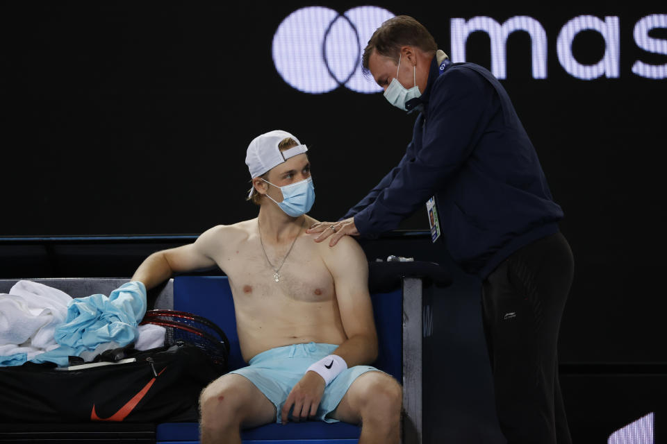 Canada's Denis Shapovalov receives a medical timeout as he plays against Italy's Jannik Sinner during the first round match at the Australian Open tennis championship in Melbourne, Australia, Monday, Feb. 8, 2021. (AP Photo/Rick Rycroft)