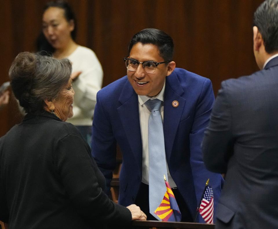 Rep. Oscar De Los Santos (center) speaks with Rep. Mae Peshlakai at the Arizona state Capitol in Phoenix on March 21, 2023.