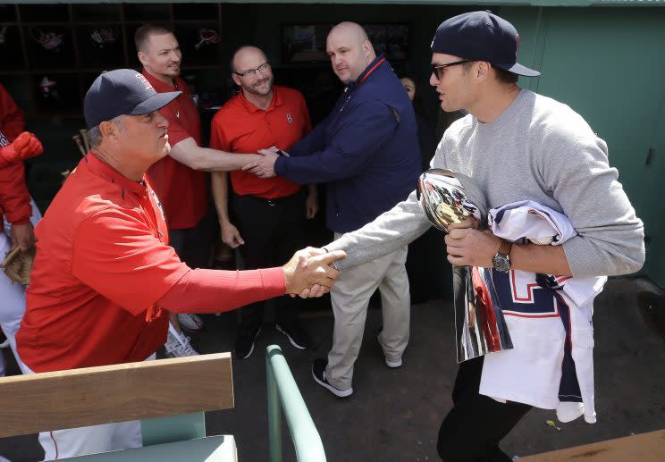 Tom Brady, with his recovered jersey, greets Red Sox manager John Farrell on opening day. (AP)