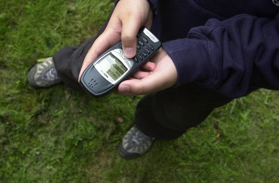 Teenage boy sending text message on mobile phone