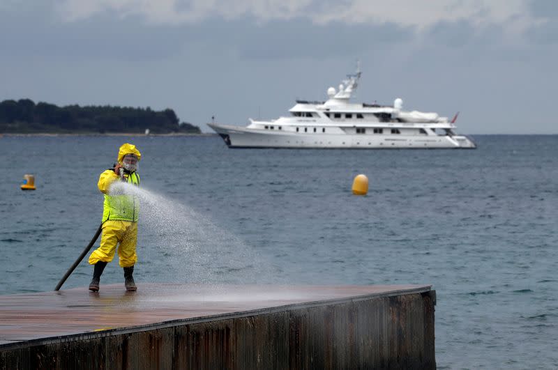 FILE PHOTO: A disinfection squad sprays disinfectant to clean beaches on the Croisette in Cannes