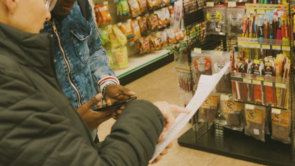 A local social worker helps Jamesson Louis plan his trip from Plattsburgh, NY to Orlando, FL inside the Mountain Mart, a Greyhound bus stop.