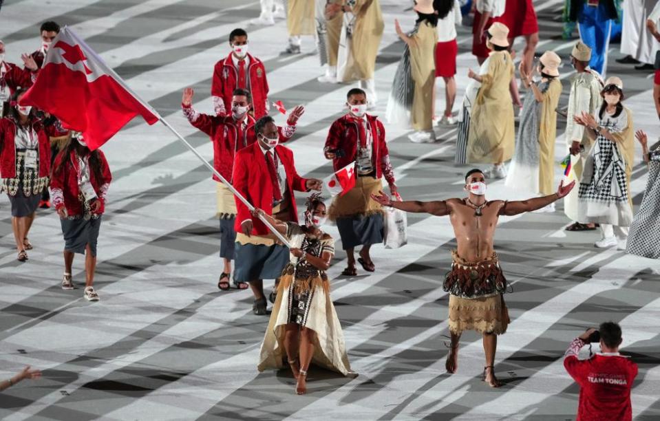 Tonga flagbearers Malia Paseka and Pita Taufatofua lead their team out during the opening ceremony.