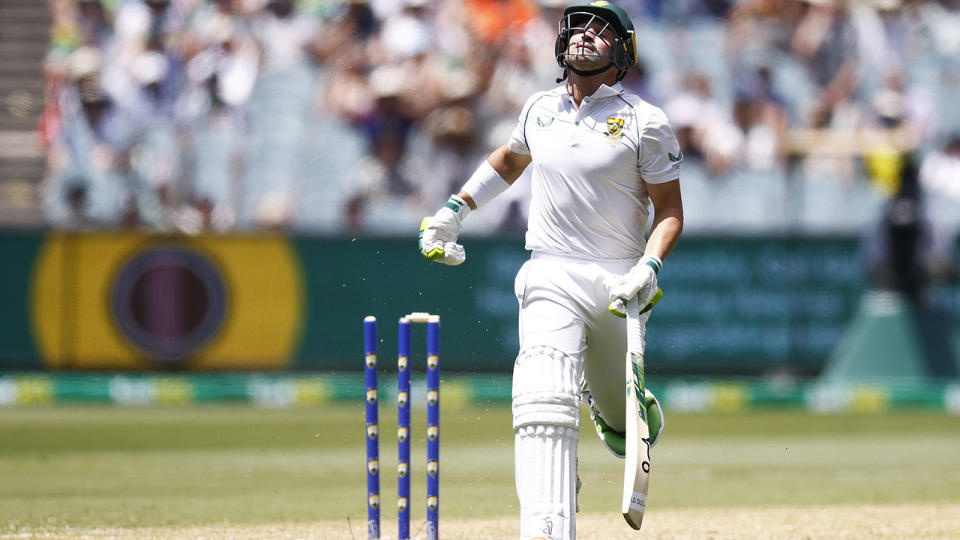 Dean Elgar reacts in frustration after being run-out by Marnus Labuschagne, with the broken stumps visible behind him.