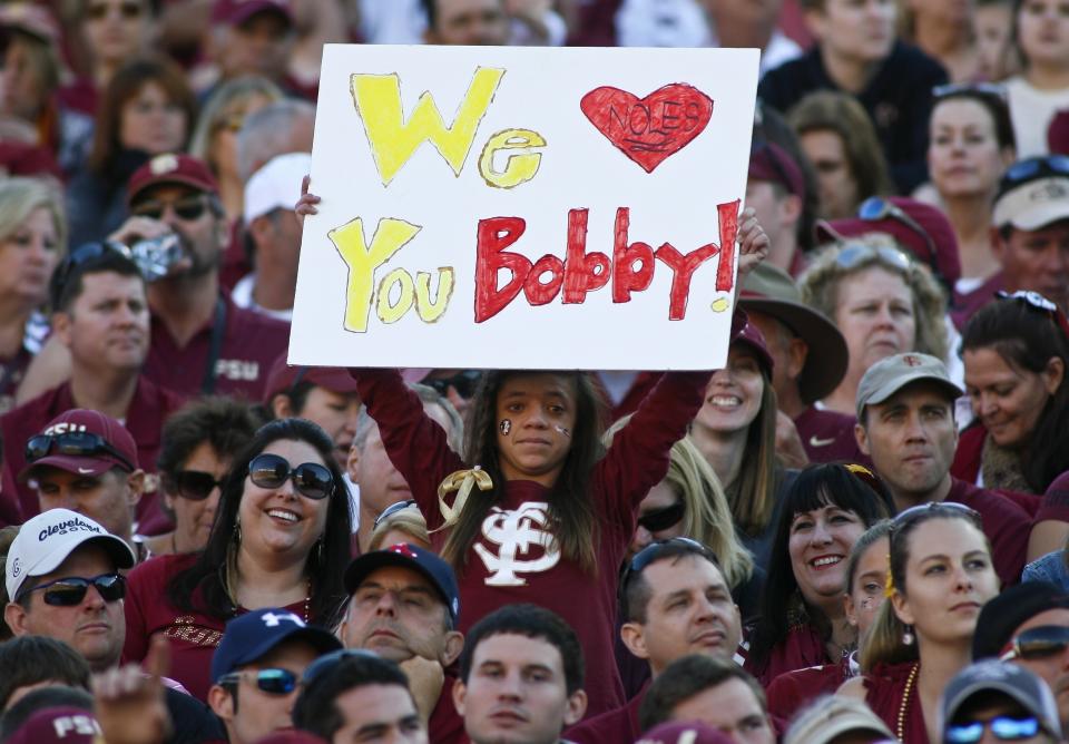 FILE - In this Oct. 26, 2013, file photo, a fan holds up a sign in support of former Florida State head coach Bobby Bowden in the second quarter of an NCAA college football game against North Carolina State in Tallahassee, Fla. Bowden, the folksy Hall of Fame coach who built Florida State into an unprecedented college football dynasty, has died. He was 91. Bobby's son, Terry, confirmed to The Associated Press that his father died at home in Tallahassee, Fla., surrounded by family early Sunday, Aug. 8, 2021. (AP Photo/Phil Sears, File)