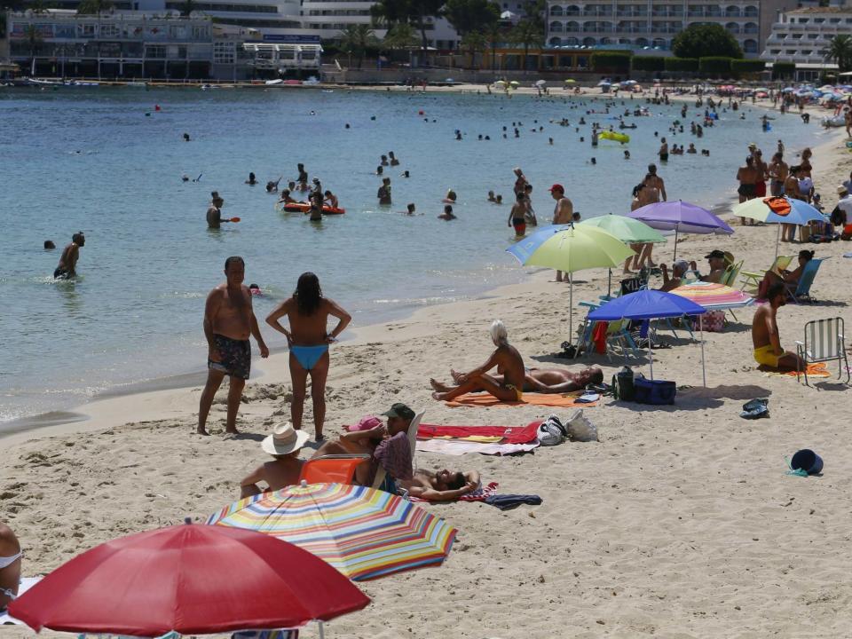 People enjoy Magaluf beach in Mallorca. Britons are surprised at the abrupt announcement to impose a two-week quarantine on people travelling to the UK from Spain: Reuters