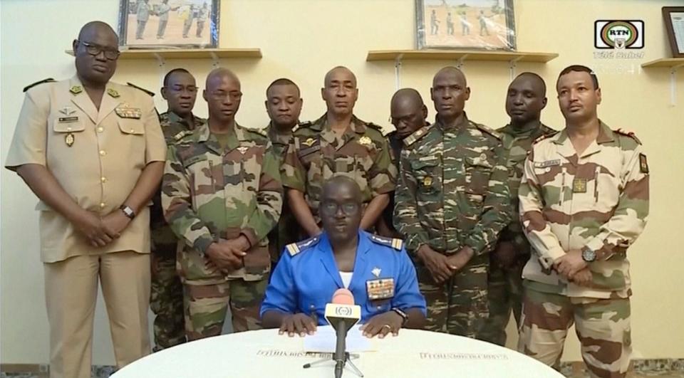 Col. Maj. Amadou Abdramane, front center, makes a statement late on July 26, 2023, in Niamey, Niger, as a delegation of military officers appeared on Niger State TV to read out a series of communiques announcing their coup d'etat.