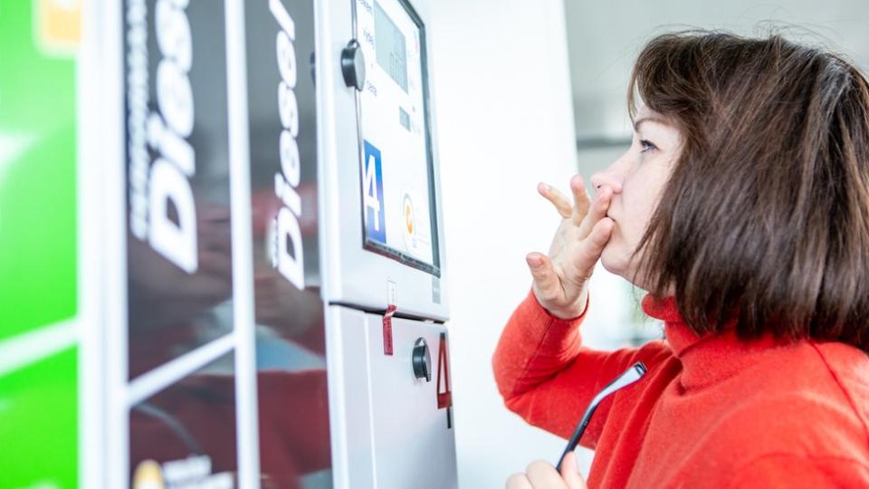 Mujer mirando precios de gasolina