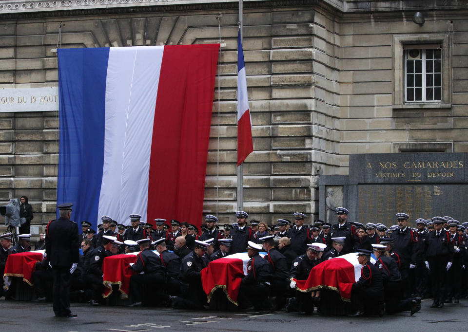 Police officers carry the coffins of the four victims of last week's knife attack during a ceremony in the courtyard of the Paris police headquarters Tuesday, Oct. 8, 2019 in Paris. France's presidency says the four victims of last week's knife attack at the Paris police headquarters will be posthumously given France's highest award, the Legion of Honor. (AP Photo/Francois Mori)