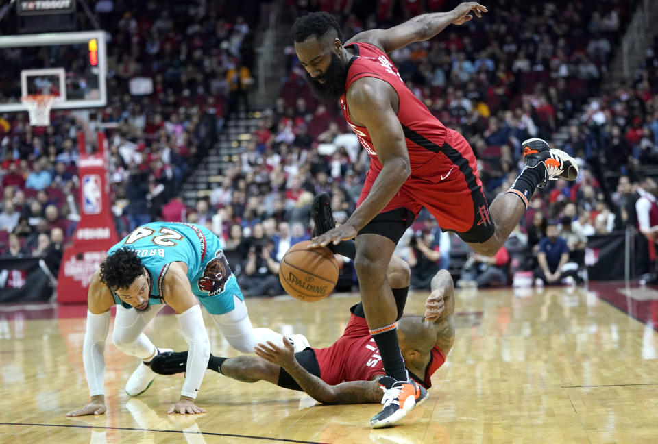 Houston Rockets' James Harden, right, avoids P.J. Tucker, center, as he falls after colliding with Memphis Grizzlies' Dillon Brooks (24) during the first half of an NBA basketball game Wednesday, Feb. 26, 2020, in Houston. Tucker was called for a foul on the play. (AP Photo/David J. Phillip)