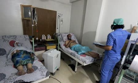 Civilians breathe through an oxygen mask at al-Quds hospital, after a hospital and a civil defence group said a gas, what they believed to be chlorine, was dropped alongside barrel bombs on a neighbourhood of the Syrian city of Aleppo, Syria, early August 11, 2016. REUTERS/Abdalrhman Ismail/Files