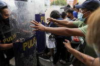 Police block activists protesting the upcoming proclamation of presidential frontrunner Ferdinand "Bongbong" Marcos and running mate Sara Duterte, daughter of the current president, during a rally at the Commission on Human Rights in Quezon City, Metro Manila, Marcos Jr. continues to lead in the official canvassing of votes. (AP Photo/Basilio Sepe)