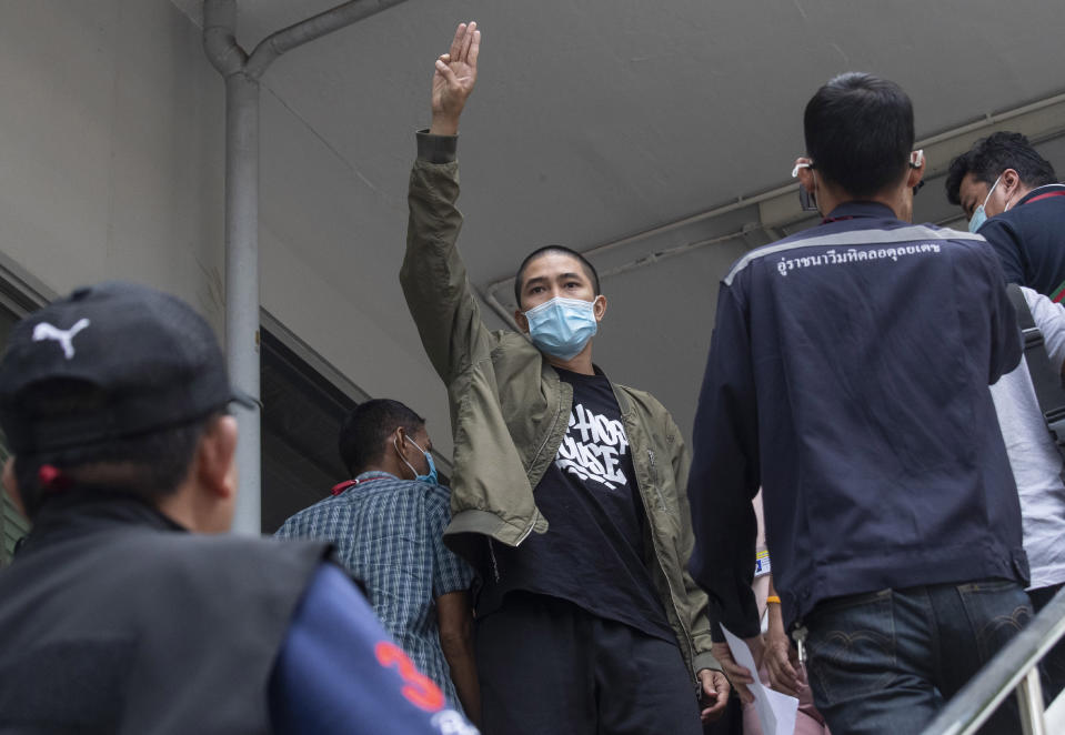 Key member of the music group Rap Against Dictatorship, Dechathorn Bamrungmuang raises a three-finger salute, a symbol of resistance, as he arrives at the Samranrat police station in Bangkok, Thailand, Thursday, Aug, 20, 2020. Thai police arrested Dechathorn and four pro-democracy activists in a crackdown on growing protests that have emerged as the most serious threat to the government led by a former army general they accuse of incompetence and corruption. (AP Photo/Sakchai Lalit)