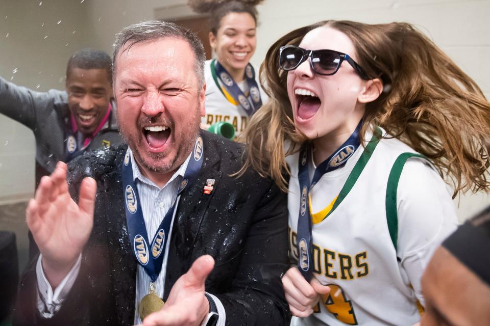 Lansdale Catholic head coach Eric Gidney gets drenched with water as he enters the locker room after the Crusaders won the PIAA Class 4A Girls' Basketball Championship against Blackhawk at the Giant Center on March 25, 2023, in Hershey. The Crusaders won, 53-45.
