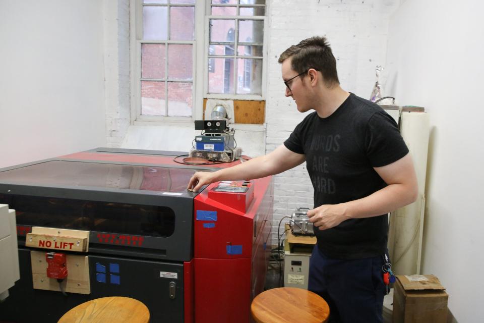 Member Paul Lane shows the laser cutter at the Framingham Makerspace, Aug. 10, 2022.