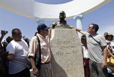 John Hemingway (L) and Patrick Hemingway (R), grandsons of the U.S. author Ernest Hemingway, pay tribute to their grandfather at his statue in Cojimar village, Havana September 8, 2014. REUTERS/Enrique De La Osa