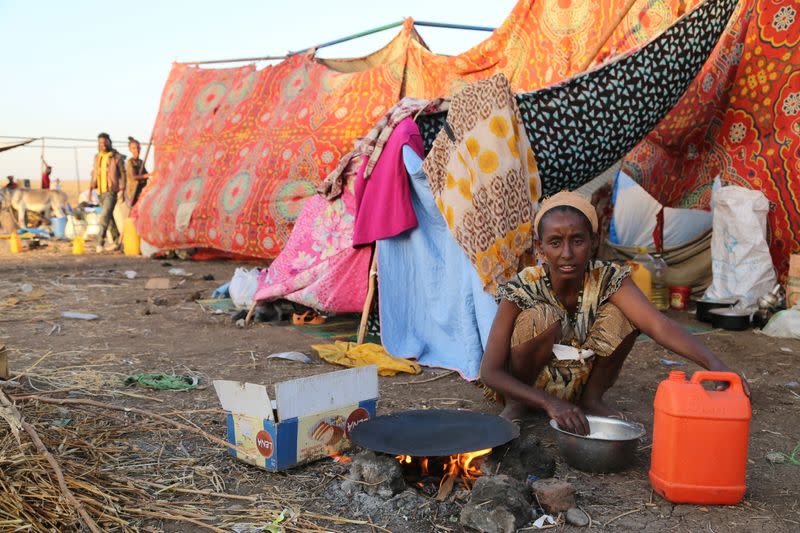 An Ethiopian who fled the ongoing fighting in Tigray region, prepares a meal before being processed for emergency food and logistics support by the WFP in Hamdait village on the Sudan-Ethiopia border in eastern Kassala state