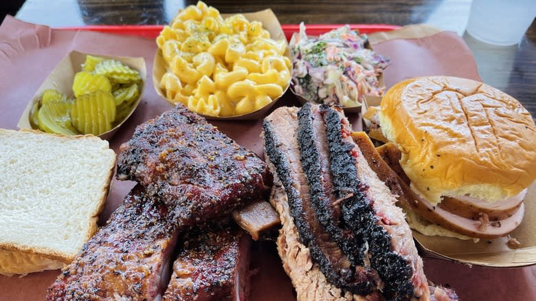 BBQ meat and sides with a tray of pickles