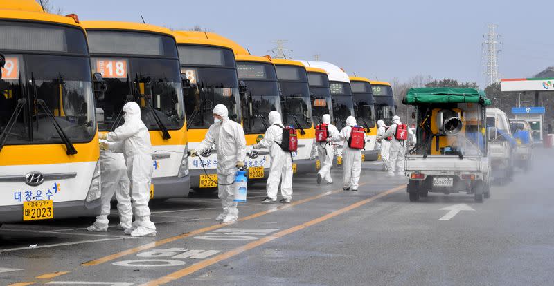 Employees from a disinfection service company sanitize a bus garage in Gwangju
