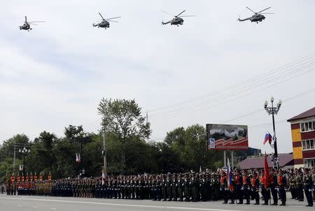 Russian military helicopters fly above servicemen standing in formation during a parade to mark the 70th anniversary of the end of the World War Two in the Far Eastern city of Yuzhno-Sakhalinsk, Russia, September 2, 2015.REUTERS/Sergei Krasnoukhov