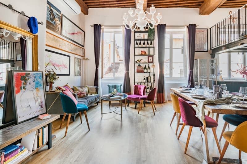 Colorful chairs across from a wooden dining room.